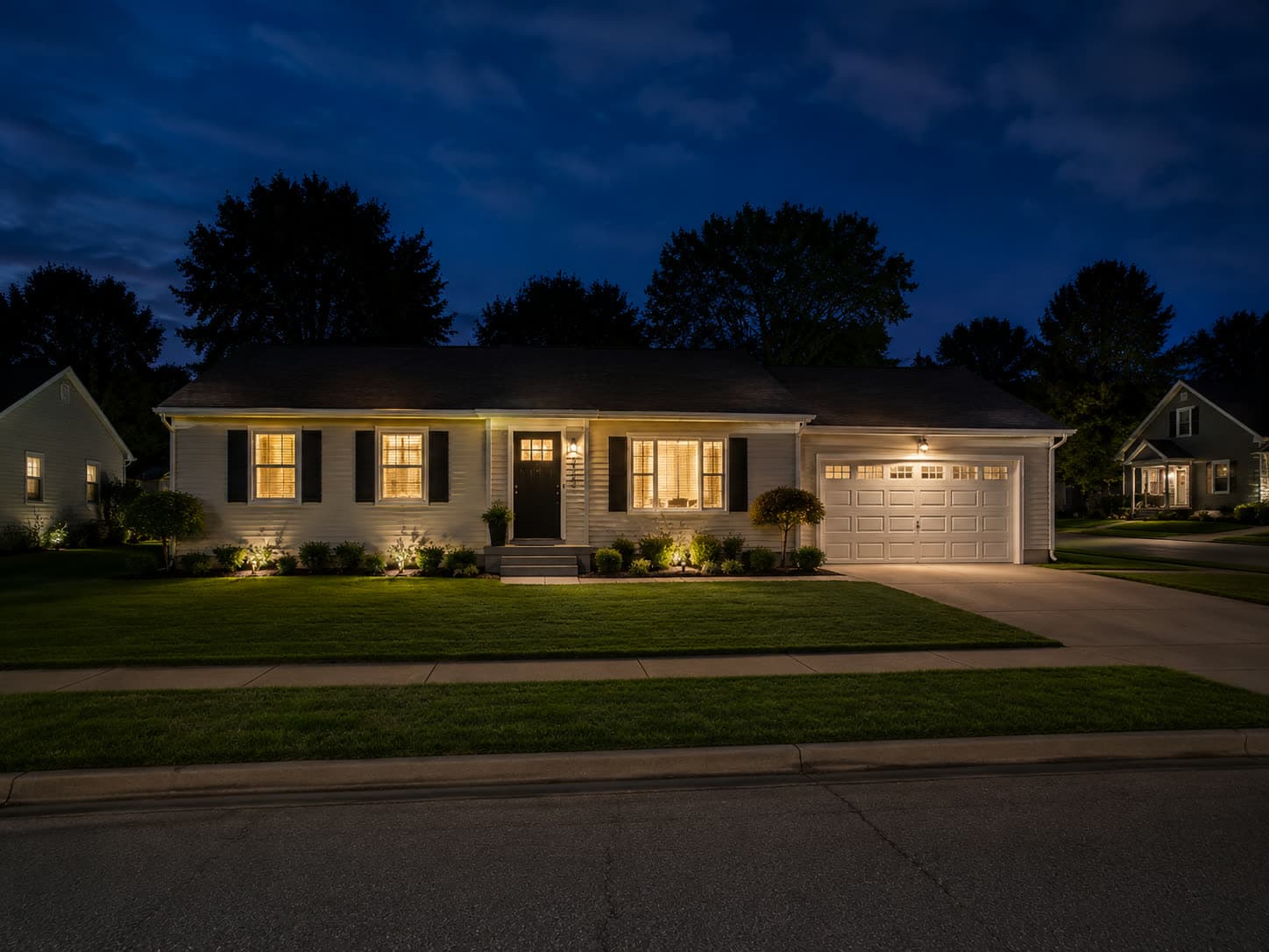 A single-family rental home with warm lights on at dusk
